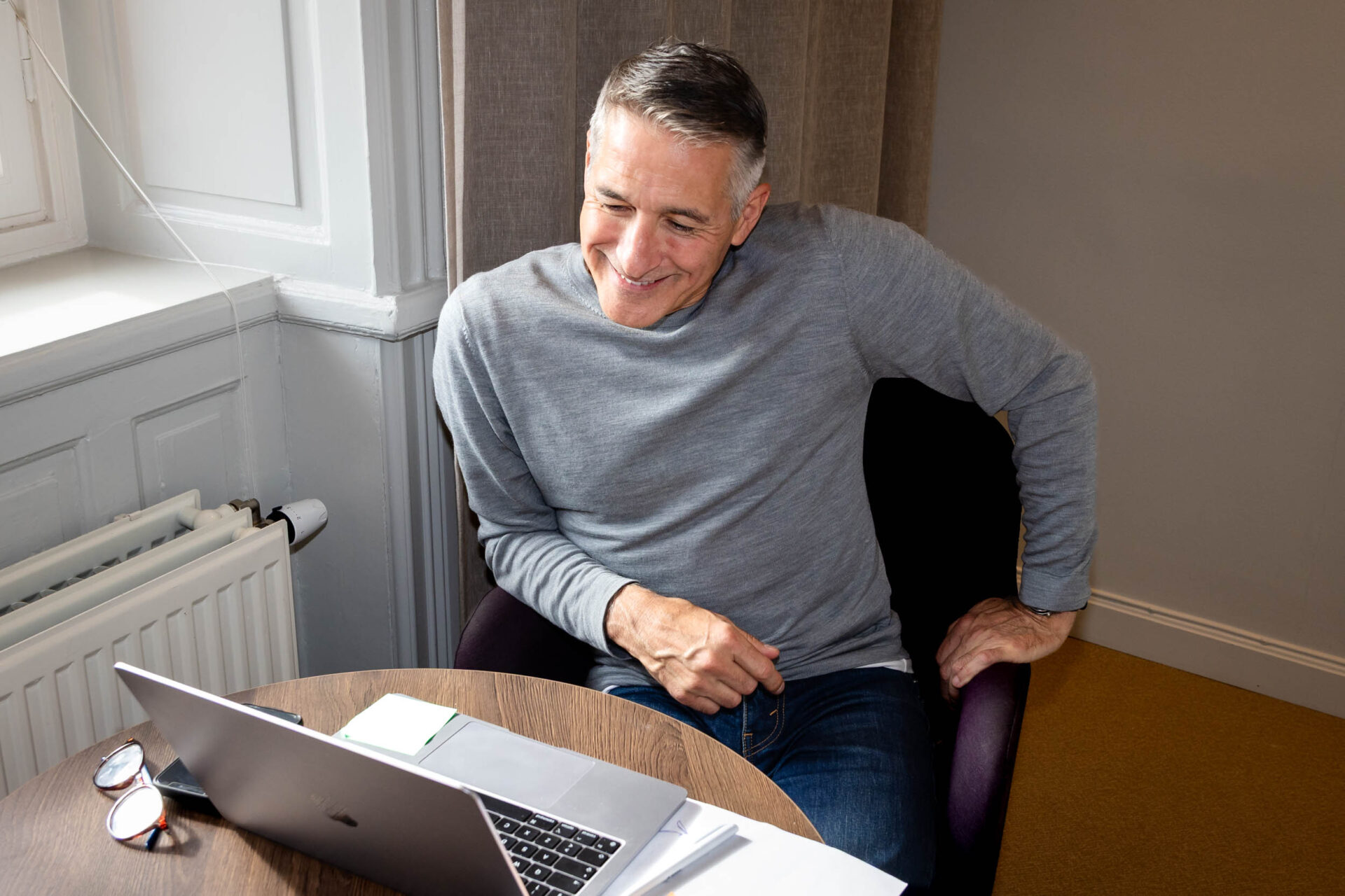 Man sitter vid skrivbord och arbetar med försäljning på laptop.