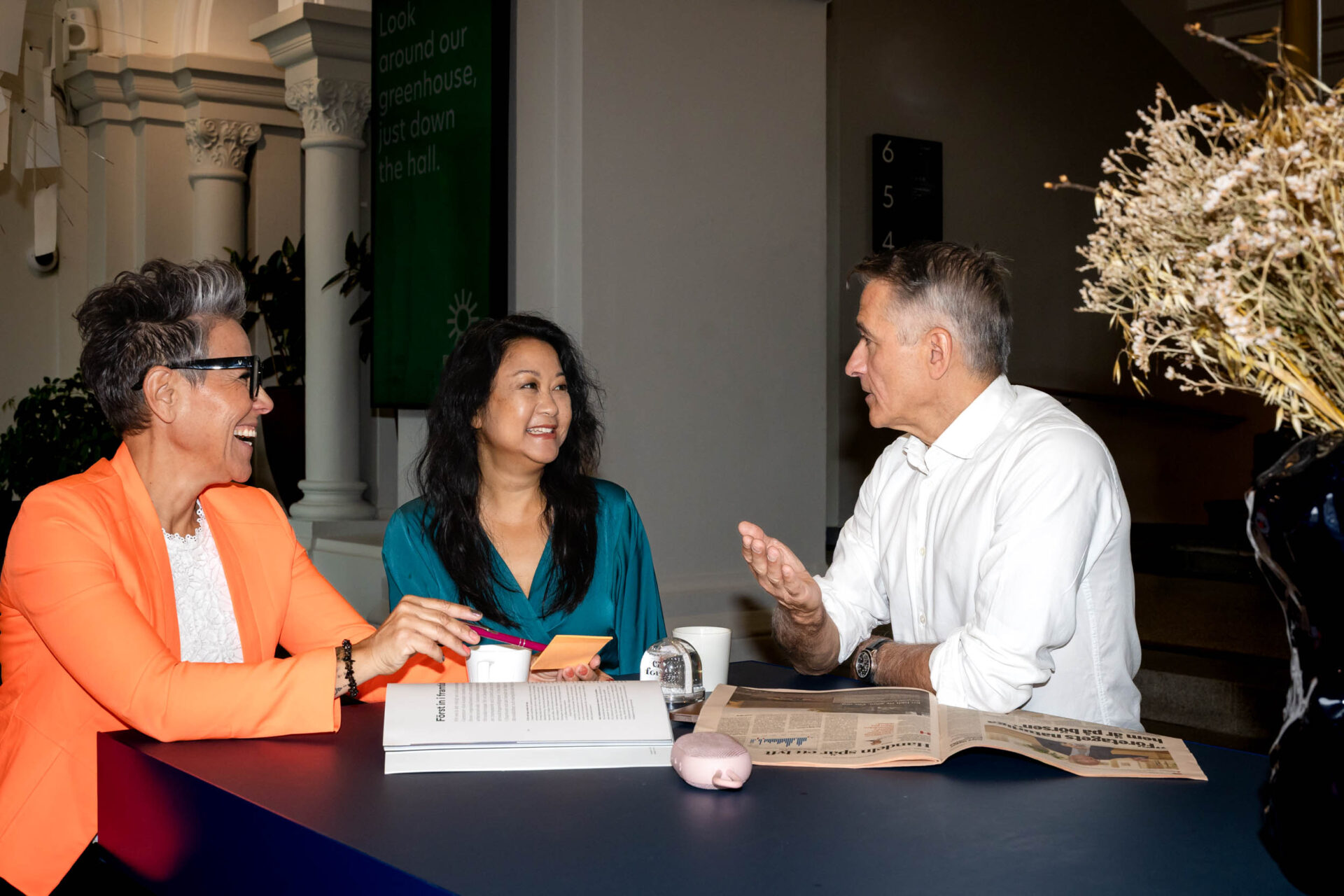 Tre personer i möte, diskuterar ekonomiska rapporter och budgetfrågor på ett modernt kontor.